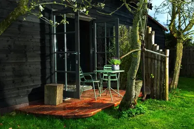 a patio with a table and a chair in a house at De koperslager in Watergang