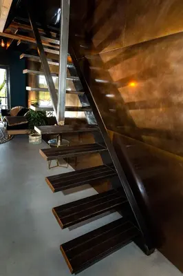 a set of wooden stairs in a room at De koperslager in Watergang
