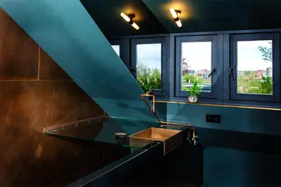 a bathroom with a sink and two windows at De koperslager in Watergang