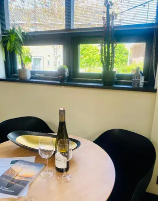 a bottle of wine sitting on a table with two glasses at Het Oude Raadhuis in Noordwijkerhout
