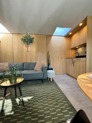 a living room with a blue couch and a table at Het Oude Raadhuis in Noordwijkerhout