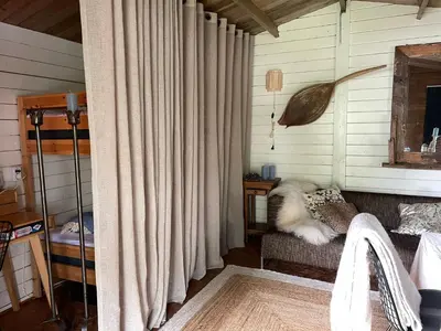 a dog laying on a couch in a room with curtains at Luxury Experience in Off The Grid Lodge at an Amazing Lake Vinkeveense Plassen in Vinkeveen