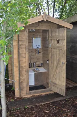 a wooden out house with a sink in it at Luxury Experience in Off The Grid Lodge at an Amazing Lake Vinkeveense Plassen in Vinkeveen