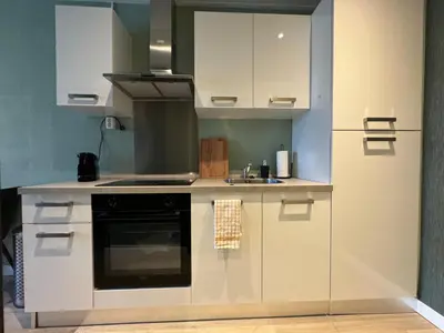 a kitchen with white cabinets and a sink at De Gouwe Stek in Landsmeer