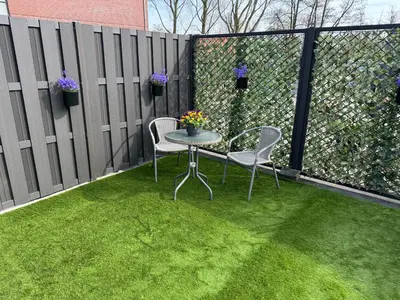 a patio with a table and chairs and a fence at De Gouwe Stek in Landsmeer