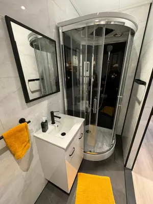 a bathroom with a white sink and a shower at De Gouwe Stek in Landsmeer