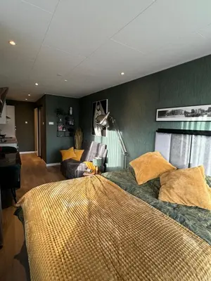 a bedroom with a large bed and a couch at De Gouwe Stek in Landsmeer
