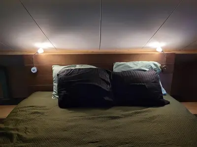 a bed with two pillows and two lights on it at Gastenverblijf rustig gelegen nabij strand en duin in Heiloo
