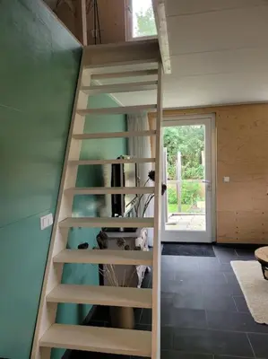 a spiral staircase in a room with a window at Gastenverblijf rustig gelegen nabij strand en duin in Heiloo