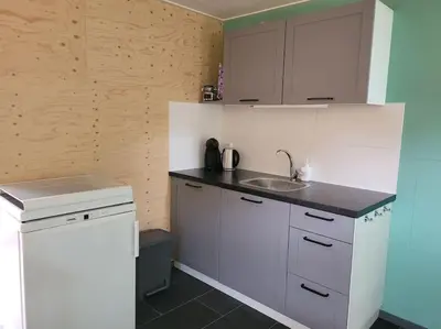 a small kitchen with a sink and a counter at Gastenverblijf rustig gelegen nabij strand en duin in Heiloo