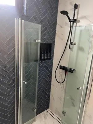 a shower with a glass door in a bathroom at Cozy & Modern Tiny House in Velserbroek