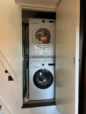 a washer and dryer in a small room at Cozy & Modern Tiny House in Velserbroek