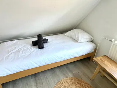 a teddy bear sitting on a bed in a room at Beach house met parkeerplaats in het centrum in Egmond aan Zee