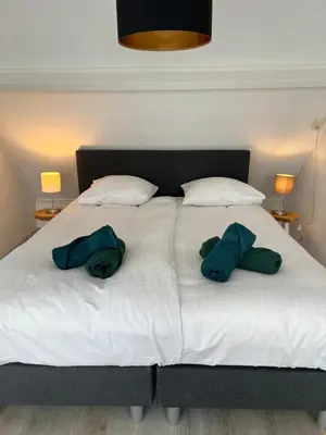 a bed with two hats and two pillows on it at Beach house met parkeerplaats in het centrum in Egmond aan Zee