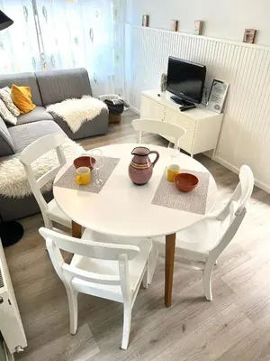 a white table and chairs in a living room at Beach house met parkeerplaats in het centrum in Egmond aan Zee
