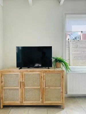 a television sitting on top of a wooden entertainment center at Hello Noordwijk - Tiny house Julianastraat 12 in Noordwijk aan Zee