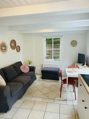 a living room with a couch and a table at Hello Noordwijk - Tiny house Julianastraat 12 in Noordwijk aan Zee