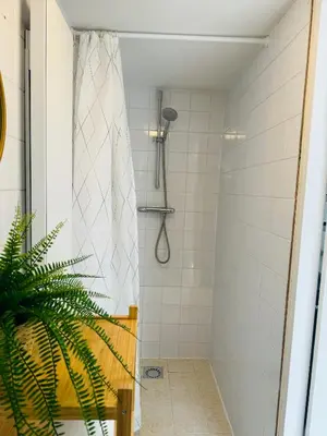 a bathroom with a shower with a plant in it at Hello Noordwijk - Tiny house Julianastraat 12 in Noordwijk aan Zee