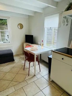 a kitchen with a white table and a chair at Hello Noordwijk - Tiny house Julianastraat 12 in Noordwijk aan Zee