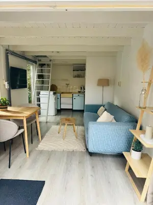 a living room with a blue couch and a table at Hello Noordwijk - Huis ter duinstraat in Noordwijk aan Zee