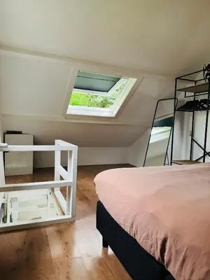 a bedroom with a bed and a window at Hello Noordwijk - Huis ter duinstraat in Noordwijk aan Zee