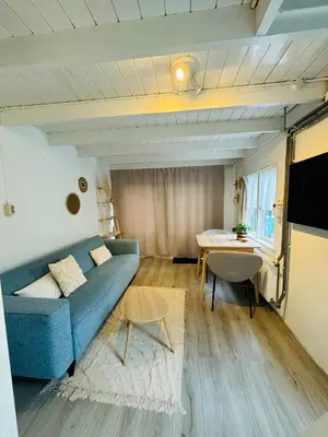 a living room with a blue couch and a table at Hello Noordwijk - Huis ter duinstraat in Noordwijk aan Zee