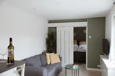 a living room with a couch and a bed at Charley's Beachhouse in Noordwijk aan Zee