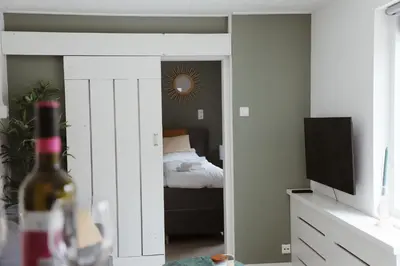 a room with a bedroom with a bed and a mirror at Charley's Beachhouse in Noordwijk aan Zee