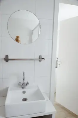 a bathroom with a white sink and a mirror at Charley's Beachhouse in Noordwijk aan Zee