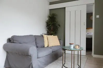 a living room with a gray couch and a table at Charley's Beachhouse in Noordwijk aan Zee