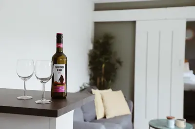 a bottle of wine sitting on a counter with two wine glasses at Charley's Beachhouse in Noordwijk aan Zee
