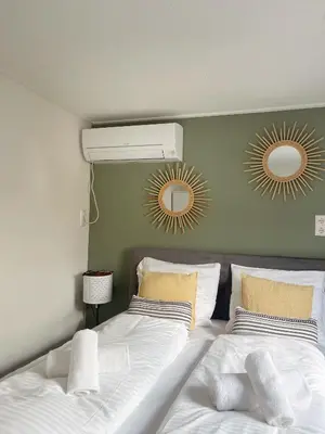 a bedroom with a bed with two mirrors on the wall at Charley's Beachhouse in Noordwijk aan Zee