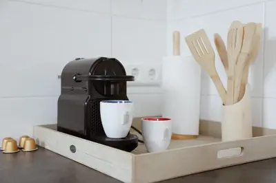 a coffee maker and two cups on a wooden tray at Charley's Beachhouse in Noordwijk aan Zee