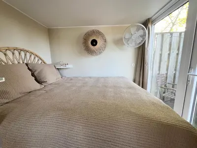 a bedroom with a large bed with a mirror on the wall at New- The Cabana- With Sauna and Hot Tub, on a lake near Amsterdam in Vinkeveen