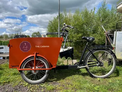 an orange bike parked next to a boat at New- The Cabana- With Sauna and Hot Tub, on a lake near Amsterdam in Vinkeveen