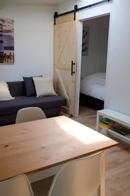 a room with a table and chairs and a couch at Beach Lodge 24 - Noordwijk aan Zee - met eigen tuin in Noordwijk