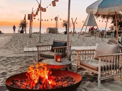 a fire pit on the beach with chairs and tables at Beach Lodge 24 - Noordwijk aan Zee - met eigen tuin in Noordwijk