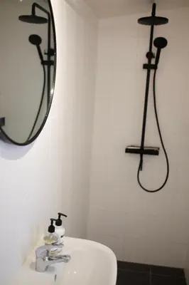 a bathroom with a sink and a mirror on the wall at Beach Lodge 24 - Noordwijk aan Zee - met eigen tuin in Noordwijk