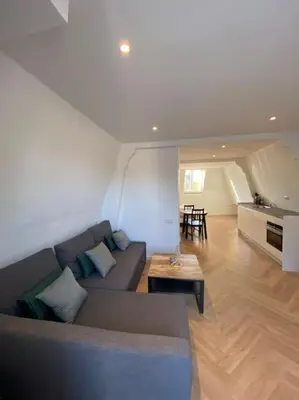a living room with a couch and a table at Apartment City Center Terrace with Iconic View in Gouda