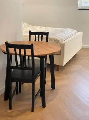 a wooden table and two chairs and a bed at Apartment City Center Terrace with Iconic View in Gouda