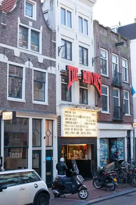 a building with a motorcycle parked in front of a store at Kuwadro Guesthouse Jordaan in Amsterdam