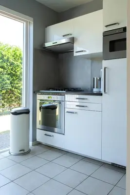 a kitchen with white appliances and a window at -Duinhuisje - voor families & honden nabij strand in Noordwijk