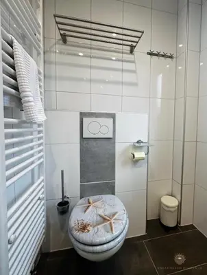 a bathroom with a toilet with a starfish seat at -Duinhuisje - voor families & honden nabij strand in Noordwijk