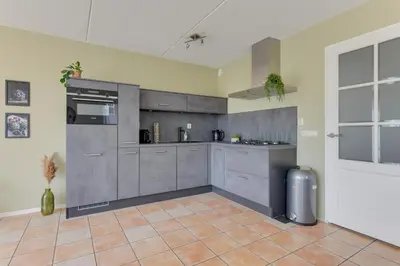 a kitchen with gray cabinets and a tile floor at Meerzicht 59 - Ideal family appt for 6 persons in Uitgeest