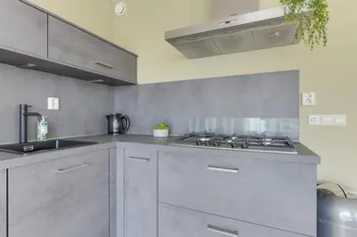 a kitchen with a sink and a stove top oven at Meerzicht 59 - Ideal family appt for 6 persons in Uitgeest