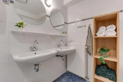 a bathroom with two sinks and mirrors on the wall at Meerzicht 59 - Ideal family appt for 6 persons in Uitgeest
