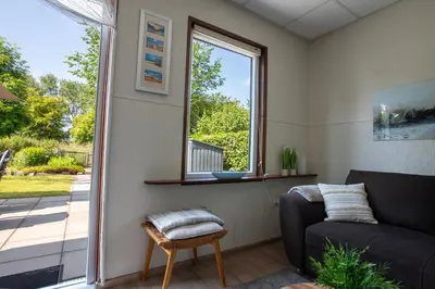 a living room with a couch and a window at Jamies Cottage Warmenhuizen nu met airco in Warmenhuizen