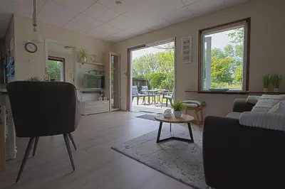 a living room with a couch and a table at Jamies Cottage Warmenhuizen nu met airco in Warmenhuizen