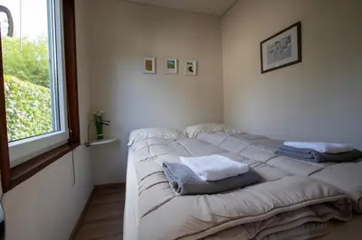 a bed in a room with two towels on it at Jamies Cottage Warmenhuizen nu met airco in Warmenhuizen