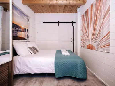 a small bedroom with a bed and a mirror at Rosa's Cottage, garden and free parking in Zandvoort